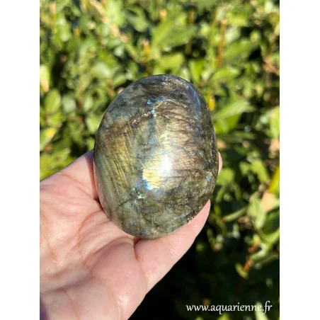 Zoom sur les reflets bleus, or, oranges de ce galet de labradorite qui s'animent selon l'exposition à la lumière.