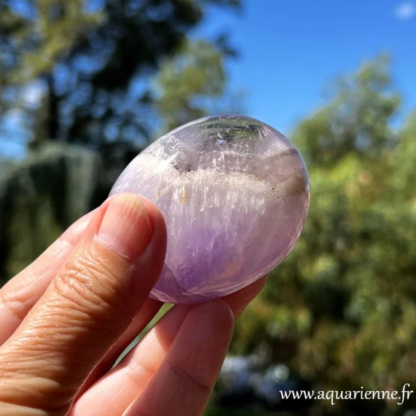 Zoom en plein soleil sur ce galet en Améthyste rubanée de Madagascar - pièce unique de 117g et 6 cm de long.