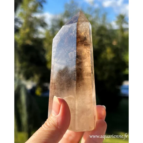 Pointe de quartz fumé de 360g illuminée par le soleil en extérieur, affichant ses nuances brunes