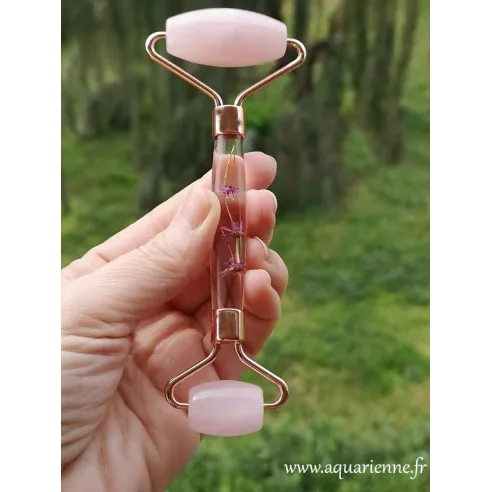 Roller facial en Quartz rose orné de fleurs roses, facile à utiliser au quotidien pour un effet lifting naturel.