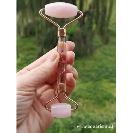 Roller facial en Quartz rose orné de fleurs roses, facile à utiliser au quotidien pour un effet lifting naturel.