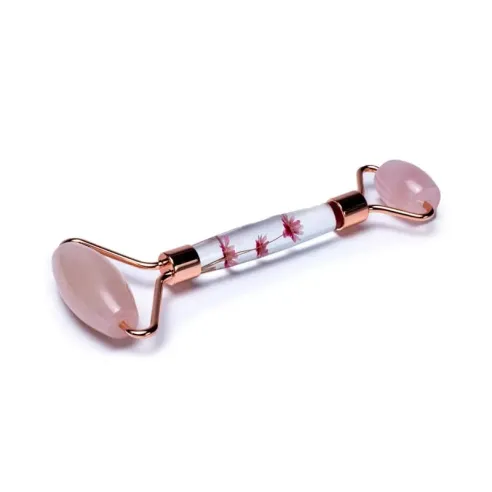 Rouleau de massage pour le visage en Quartz rose avec fleurs roses pour un soin profond et antiâge, révélateur d'éclat.