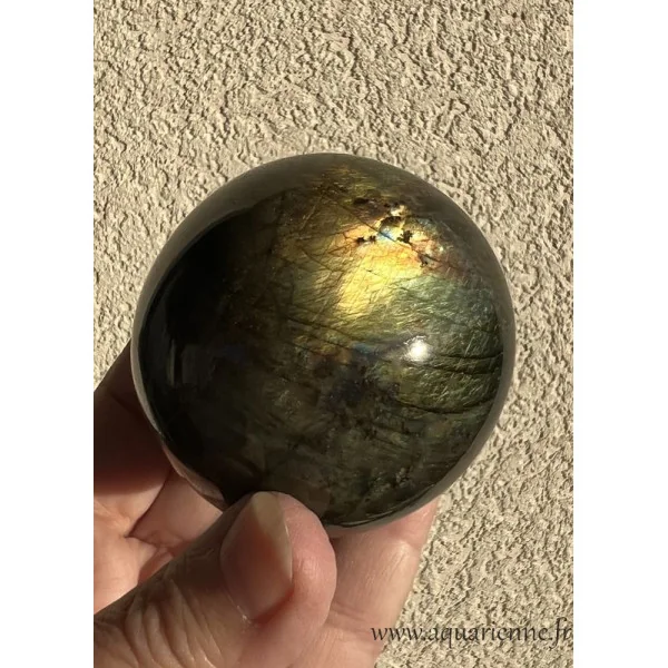 Les reflets dorés de cette sphère de Labradorite apparaissent au soleil. Sphère de labradorite de 58 mm de diamètre.