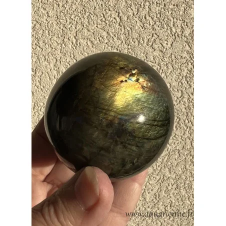 Les reflets dorés de cette sphère de Labradorite apparaissent au soleil. Sphère de labradorite de 58 mm de diamètre.