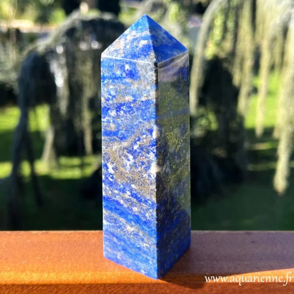 Bleu profond sublimé de veines dorées de pyrite et de touches de calcite blanche pour cet obélisque en Lapis lazuli.