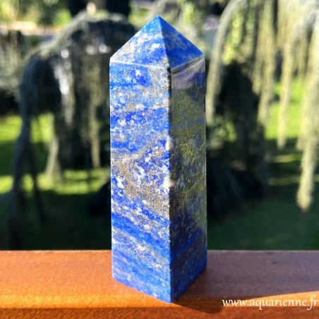 Bleu profond sublimé de veines dorées de pyrite et de touches de calcite blanche pour cet obélisque en Lapis lazuli.