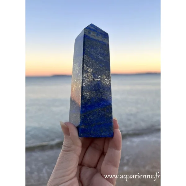 Face à la mer et au soleil couchant, admirez le scintillement doré de la pyrite sur ce bel obélisque en lapis-lazuli de 14 cm.