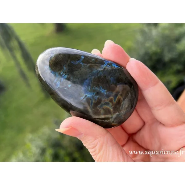 Reflets multi-feux d'un côté et bleutés de l'autre pour ce beau galet poli de Labradorite de Madagascar.