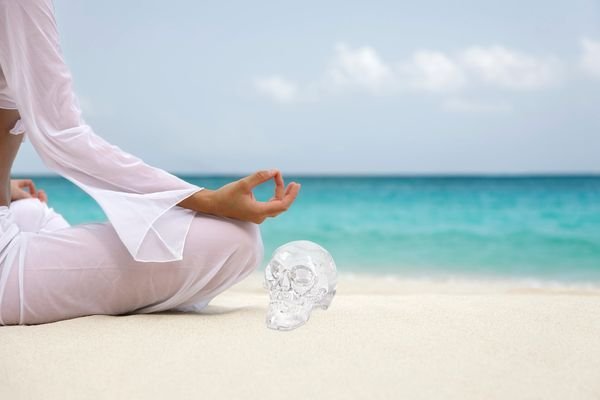 Devenir gardien de crânes de cristal - méditation sur la plage avec un crâne de cristal